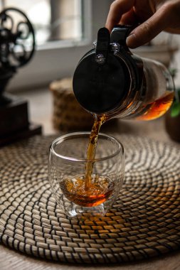 Narin bir fincanda çay ile samimi bir sahne rahatlık ve derin bir rahatlama getirir, deneyimi güçlendirir.