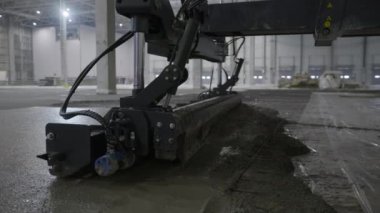 Robotik betonun yakın çekim görüntüsü geniş bir sanayi bölgesinde yeni bir yüzeyi verimli bir şekilde pürüzsüz hale getiriyor. Kırp