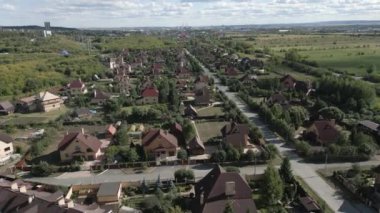 Her yerde yemyeşil manzaralar sergilenen huzurlu ve sakin bir banliyö mahallesinin çarpıcı hava görüntüsü. Kırp