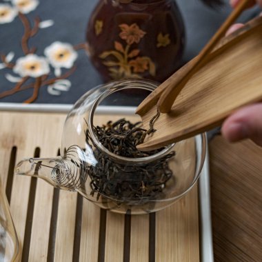 Yumuşak bir yaprak çayı sahnesi bambu aletleriyle hazırlanıyor, geleneksel çay kültürü sergileniyor..