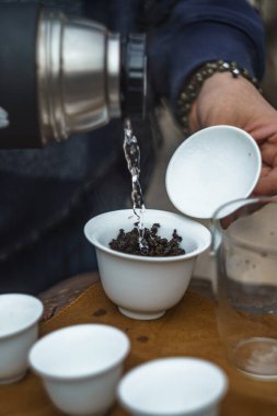 In this tranquil moment, hot water is gently poured over the delicate tea leaves during tea preparation clipart