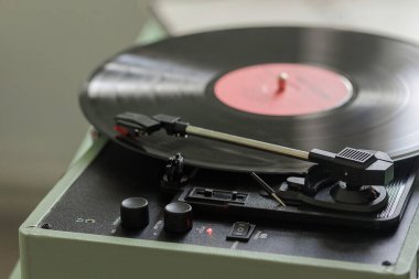 Klasik bir turntable, nostalji ve müziğe karşı derin bir tutku uyandıran, sevilen bir plak plağını zarifçe çevirir.