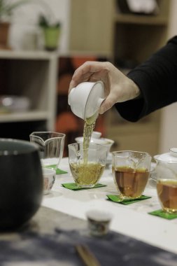 Bir el zarif bardaklara aromatik çay döker. Huzurlu ve rahatlatıcı bir ortamda kaynaşma sanatını yakalar.