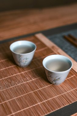 Narin çay fincanlarıyla bir bambu hasırının üzerinde huzurlu bir ortam, rahatlama ve kültürel takdir için mükemmel.