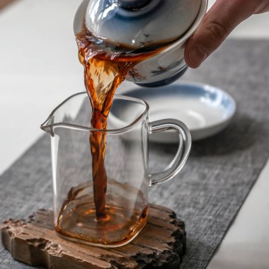 Huzurlu ve huzurlu bir anda, çay geleneksel bir çaydanlıktan berrak bir bardağa dökülüyor.