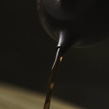 Yakından bakınca, zengin, koyu bir sıvının zarif bir çaydanlıktan güzel bir kaseye atıldığını görüyoruz.