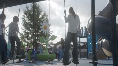 Çek Cumhuriyeti, Prag - 17 Ağustos 2024: Bu güneşli günde, çocuklar neşeli bir halk oyun alanında salıncakların ve oyun ekipmanlarının keyfini çıkarıyorlar