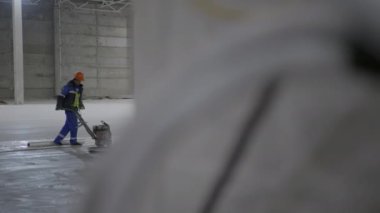 Kendini işine adamış bir işçi geniş bir sanayi bölgesinin temizliğini sağlamak için büyük bir yer temizleme makinesi kullanıyor. Kırp