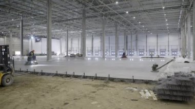 Yeni dökülmüş beton zemini olan geniş bir deponun inşaatı devam ediyor. Kırp