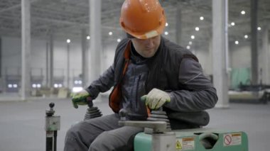 Yetenekli bir işçi, güvenlik ve uzmanlığı vurgulayarak endüstriyel alanda ağır makineleri ustalıkla çalıştırır. Kırp