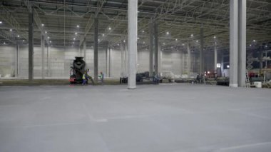 Endüstriyel kullanım için tasarlanmış, devam eden inşaat sürecini ön plana çıkaran büyük ve boş bir depo. Kırp