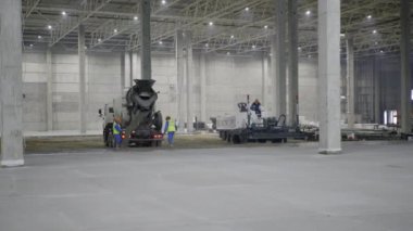 Geniş bir inşaat sahasında çeşitli ağır makineler ve devam eden çalışmalar sergileniyor. Kırp