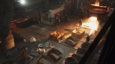 Hareketli bir endüstriyel dökümhane, kendini işine adamış işçilerle birlikte erimiş metal döküm sergiliyor. Menkul Kıymetler