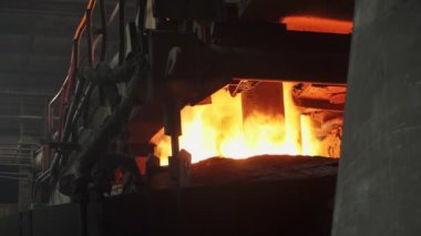 Endüstriyel bir dökümhanede, sıcak erimiş metal fırından sorunsuzca akıyor, zanaat ve enerji sergiliyor. Menkul Kıymetler
