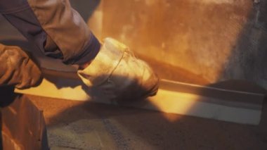 Yetenekli bir işçi, erimiş metali koruyucu eldiven giyerken manipüle eder. Menkul Kıymetler