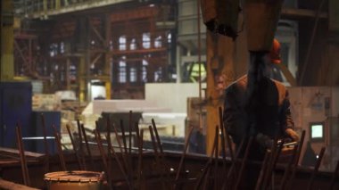 Yetenekli bir işçi yoğun endüstriyel ortamda karmaşık makineleri ustalıkla yönetir. Menkul Kıymetler