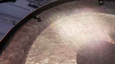 Eşsiz dokusunu ve büyüleyici yansımalarını güzel bir şekilde sergileyen bir gong yüzeyinin karmaşık detaylı bir görüntüsü. Kırp