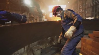 Kendini endüstriyel bir çevreye adamış işçiler, takım çalışması ve işçilik becerilerini açıkça gösteriyorlar. Menkul Kıymetler