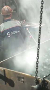 Endüstriyel bir çevredeki işçiler, olağanüstü bir işçilik ve beceri sergileyerek erimiş metali ustalıkla idare ediyorlar. Menkul Kıymetler