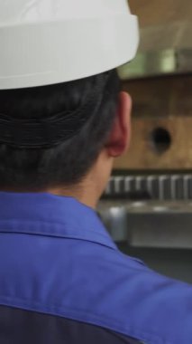 Bir sanayi işçisi, bir üretim tesisi içinde ağır makinelerin çalışmasını dikkatle izliyor. Menkul Kıymetler