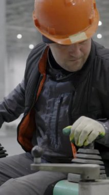 Yetenekli bir işçi, güvenlik ve uzmanlığı vurgulayarak endüstriyel alanda ağır makineleri ustalıkla çalıştırır. Kırp