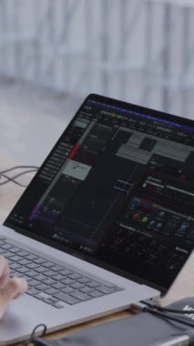Gelişmiş ses donanımına bağlı yüksek performanslı bir dizüstü bilgisayar, modern bir müzik prodüksiyonu kurulumunu gösteriyor. Kırp