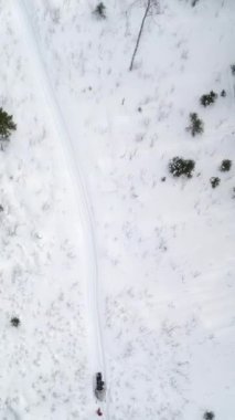 Hava manzarası, kıvrımlı bir yolu olan karlı bir ormanı gösteriyor. Kışları sakin ve dingin kışı gösteriyor. Menkul Kıymetler