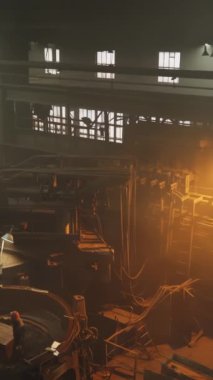 Karamsar ve atmosferik bir endüstriyel ortam sisli ve sisli bir arkaplan arasında sıcak ışıklandırma sergiliyor. Menkul Kıymetler