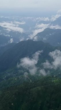 Canlı yemyeşil ve sürüklenen bulutlarla çevrili sisli dağların nefes kesici ve çarpıcı görüntüsü. Menkul Kıymetler