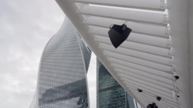 Bulutlu ve bulutlu bir gökyüzüne karşı inşa edilmiş çağdaş yapıların çarpıcı ve büyüleyici bir görüntüsü. Eylem