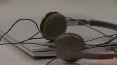 Şık bir kulaklık şık bir dizüstü bilgisayarın üzerinde rahatça dinleniyor ve çağdaş bir çalışma düzeneği sergiliyor. Stock Görüntüsü