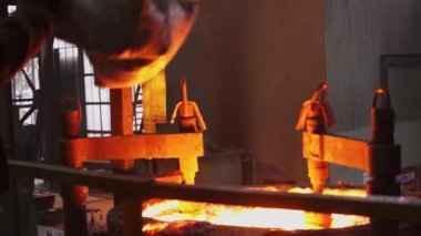 Bu, yoğun bir dökümhane ortamında erimiş metalin ustalıkla manipüle edildiği yoğun ve dinamik bir sahneyi tasvir ediyor. Menkul Kıymetler