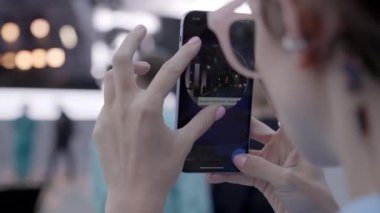 Bir kişi, modern medyanın etkileşimini gösteren akıllı telefonunu kullanarak heyecan verici bir olayı yakalıyor. Kırp