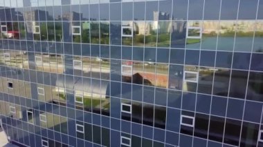 Çarpıcı bir şekilde tasarlanmış, çevre kentsel manzara ve çevreyi güzel bir şekilde yansıtan modern cam bir bina. Kırp