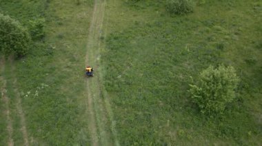 Havadan bakıldığında, canlı yeşil bir arazide ustalıkla gezinen bir biçici doğanın güzelliğini ön plana çıkarıyor. Kırp