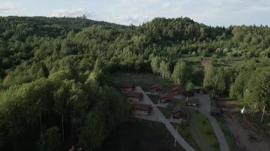 Serin bir hava manzarası, yemyeşil alanlarda büyüleyici kır kulübelerinin yer aldığı güzel bir orman inzivası sergiliyor. Kırp