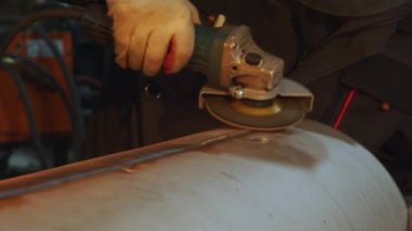 Yetenekli bir işçi metal bir boru üzerinde ustalıkla öğütücü kullanır, bu da zanaat ve sanayi uzmanlığını gösterir. Medya