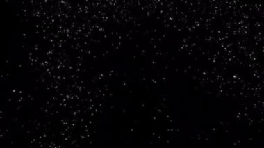Bu video kayan kar taneleri ve parıldayan yıldızlarla birlikte sakin, siyah bir zemin gösteriyor. Güzelliği yansıtan sakin bir kış ortamı yaratıyor.