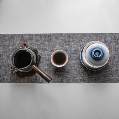 Estetik üst görünüm kahve demleme ekipmanları minimalist bir masada bir fincanın yanında zarif bir şekilde düzenlenir.