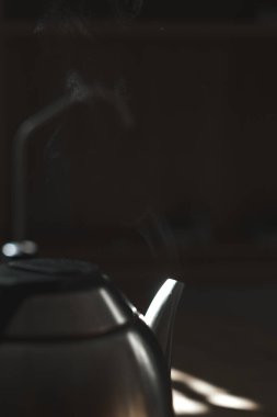 Güzel tasarlanmış bir çaydanlık, sıcak ışıkla aydınlatılan yumuşak buharı serbest bırakır ve rahat bir atmosfer yaratır.