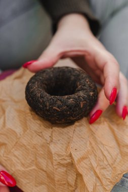 Eşsiz bir siyah çörek dokulu kağıt üzerinde dinleniyor, yaratıcı sunumu ve cesur estetiği vurguluyor..