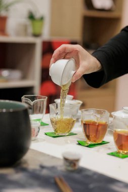 Bir el zarif bardaklara aromatik çay döker. Huzurlu ve rahatlatıcı bir ortamda kaynaşma sanatını yakalar.