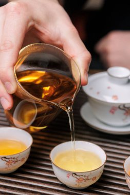 Enfes geleneksel çay fincanları ve güzel bir çaydanlık içeren zarif ve güzel bir çay doldurma sahnesi.