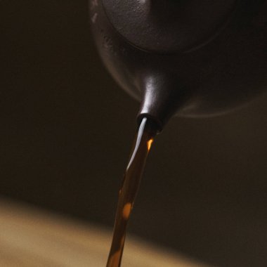 Yakından bakınca, zengin, koyu bir sıvının zarif bir çaydanlıktan güzel bir kaseye atıldığını görüyoruz.