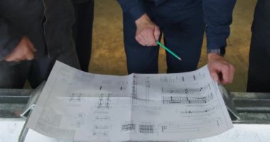 Deneyimli profesyoneller, inşaat ve tasarım projeleri için hayati önem taşıyan ayrıntılı planları ayrıntılı bir şekilde inceliyorlar. Medya