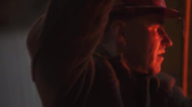 Odaklanmış bir işçi loş bir ortamda görevini sürdürürken parlak bir ışık makinesiyle aydınlatılır. Menkul Kıymetler