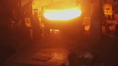 Bu yoğun görüntü, yoğun bir dökümhaneye dökülen erimiş çeliğin endüstriyel süreci gösterdiğini gösteriyor. Menkul Kıymetler