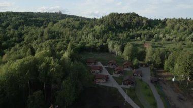 Serin bir hava manzarası, yemyeşil alanlarda büyüleyici kır kulübelerinin yer aldığı güzel bir orman inzivası sergiliyor. Kırp