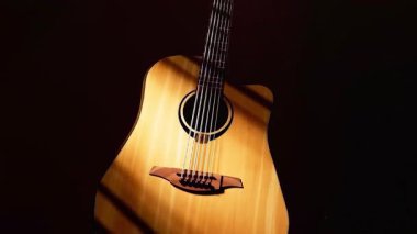 Yumuşak ışıklandırmada zarif bir akustik gitar, fevkalade işçiliğini ve eşsiz tasarımını sergiliyor.