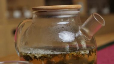 Bu video, cam bir çaydanlıkta yeşil çay demleme sürecinin dingin sürecini gösteriyor, akarken canlı rengini ve aromasını yakalıyor. Medya